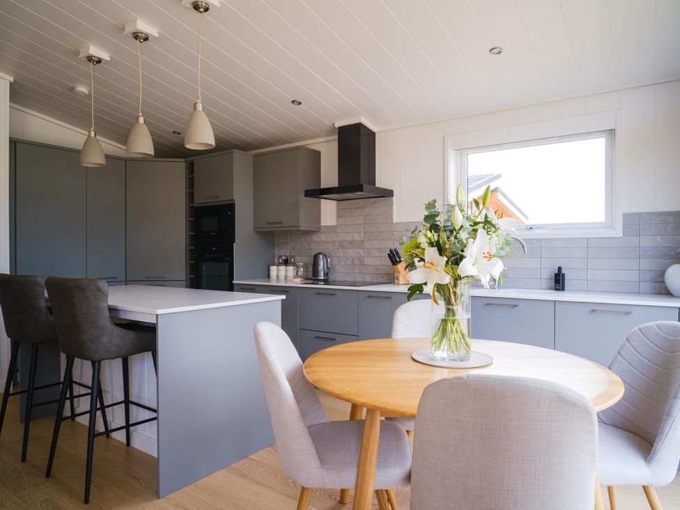 A kitchen with an island and dining area at The Luxury Retreat in Waltham