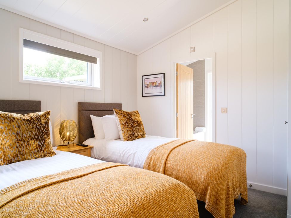 A bedroom with two beds and a lamp at The Luxury Retreat in Waltham