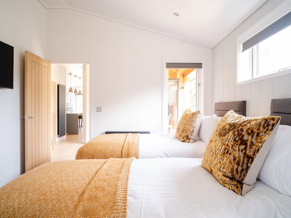 A bedroom with two beds and a doorway leading to another room at The Luxury Retreat in Waltham