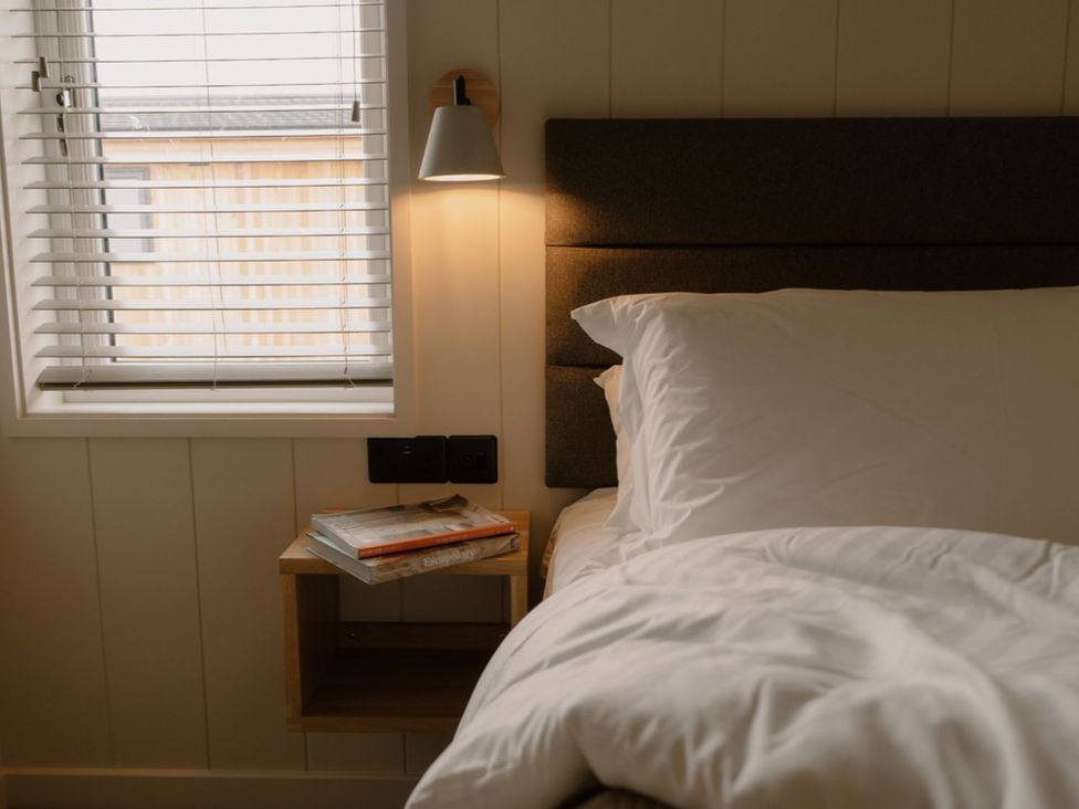 A bedroom with a bed and nightstand at Luxury Boutique Retreat Spa in Waltham