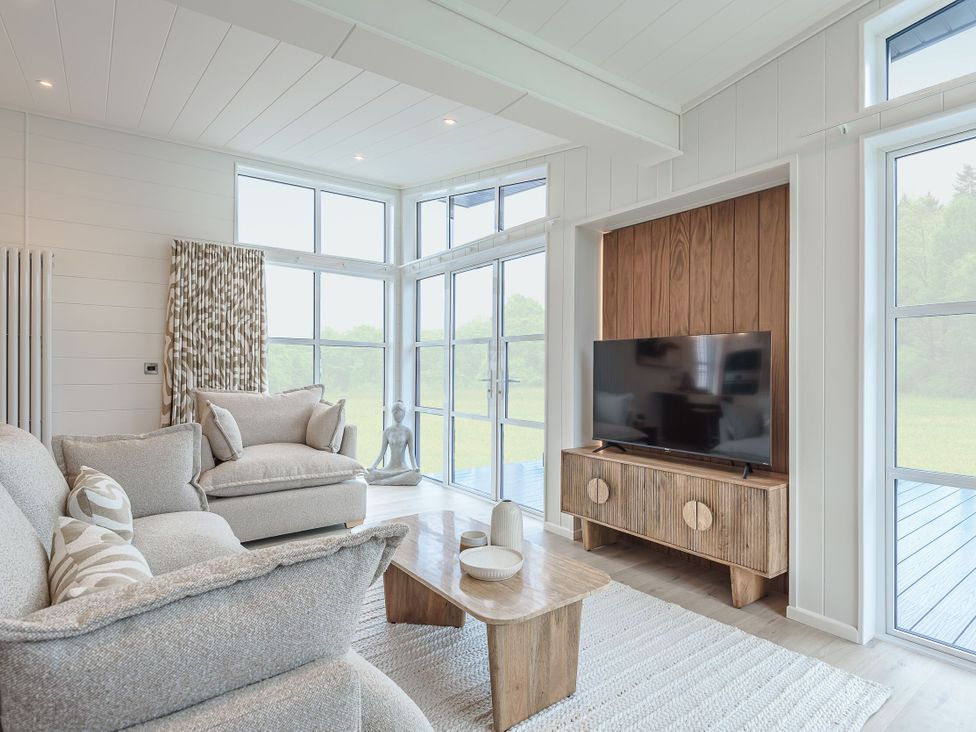 A living room with a sofa and television at Exclusive Aura Spa in Waltham