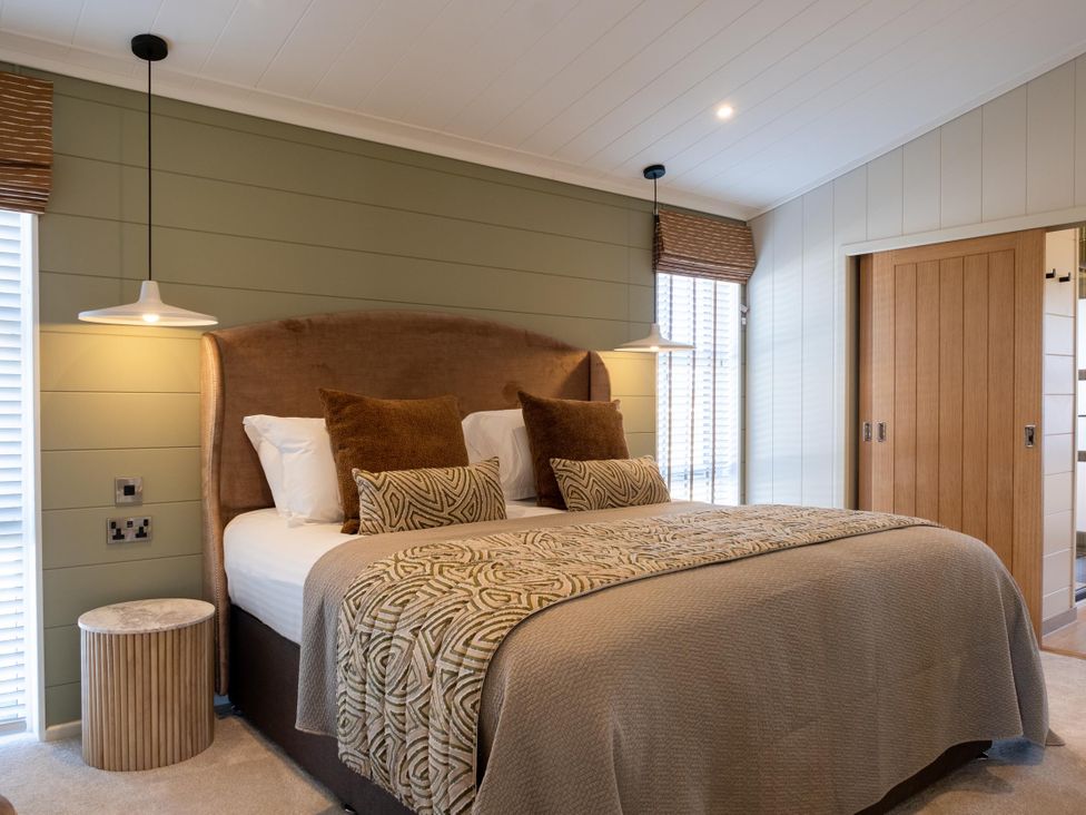 A bedroom with a bed and bedside lamps at Exclusive Aura Spa in Waltham