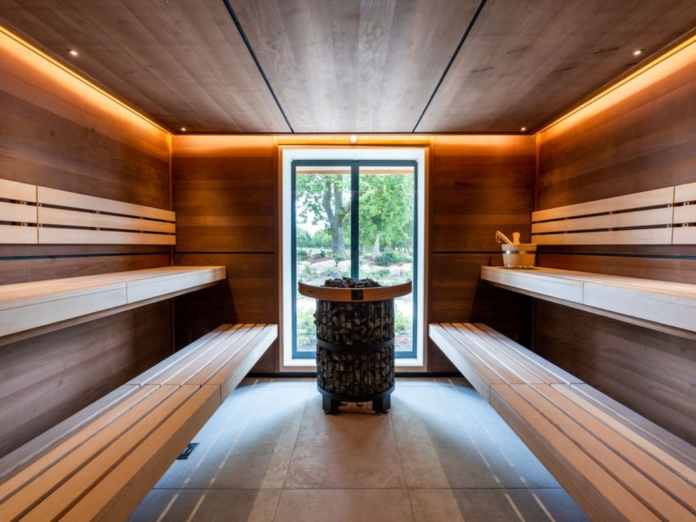 A sauna with wooden benches and a window at Exclusive Aura Spa in Waltham