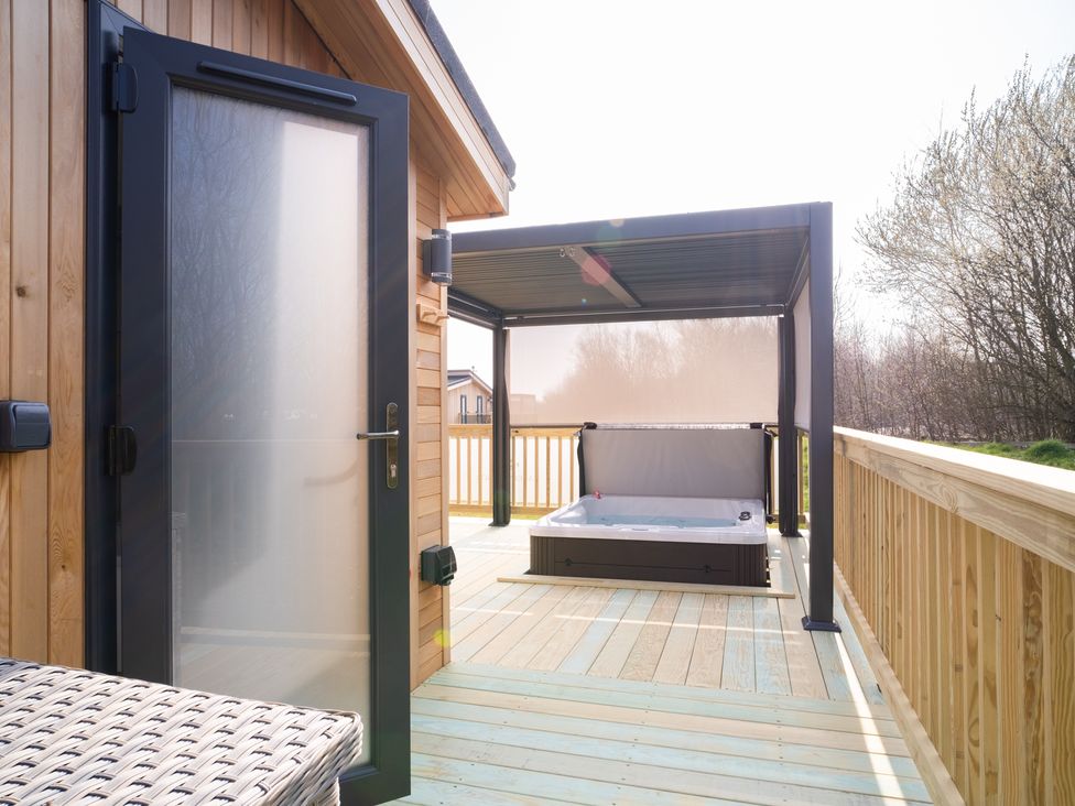 An outdoor area with a hot tub on a deck at Hamilton in Waltham