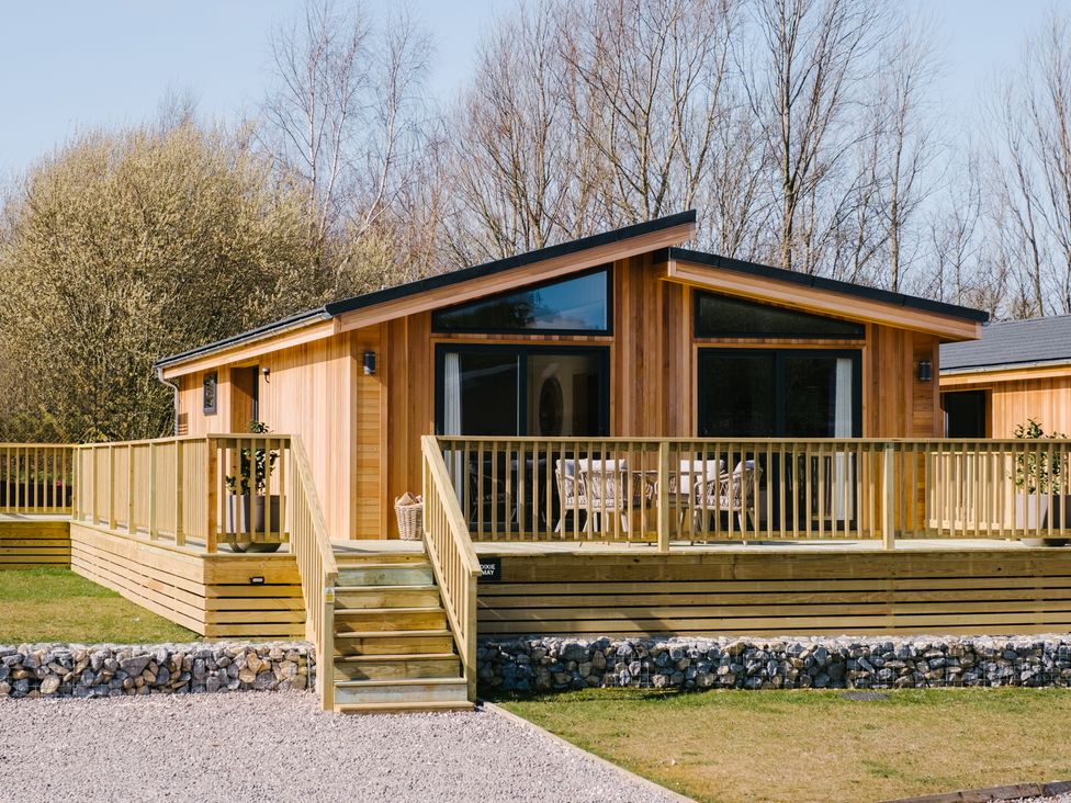 A wooden cabin with a deck and stairs at Marrakech in Waltham