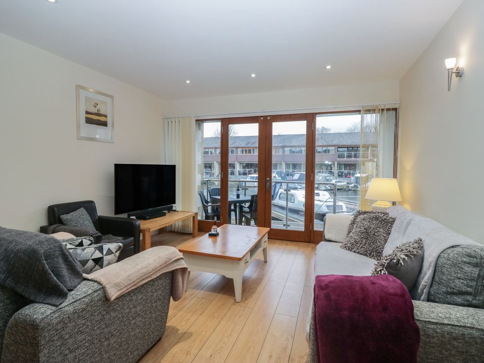 A living room with a television and sofas at 6 Swan House in Tewitfield