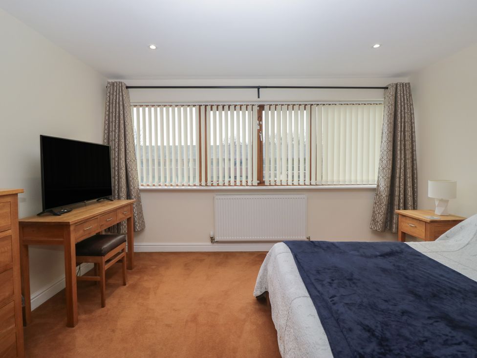 A bedroom with a television, desk, and bed at 6 Swan House in Tewitfield