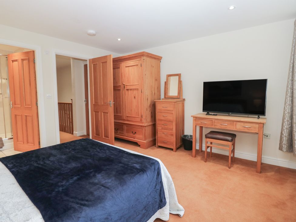 A bedroom with a bed, wardrobe, television, and dresser at 6 Swan House in Tewitfield