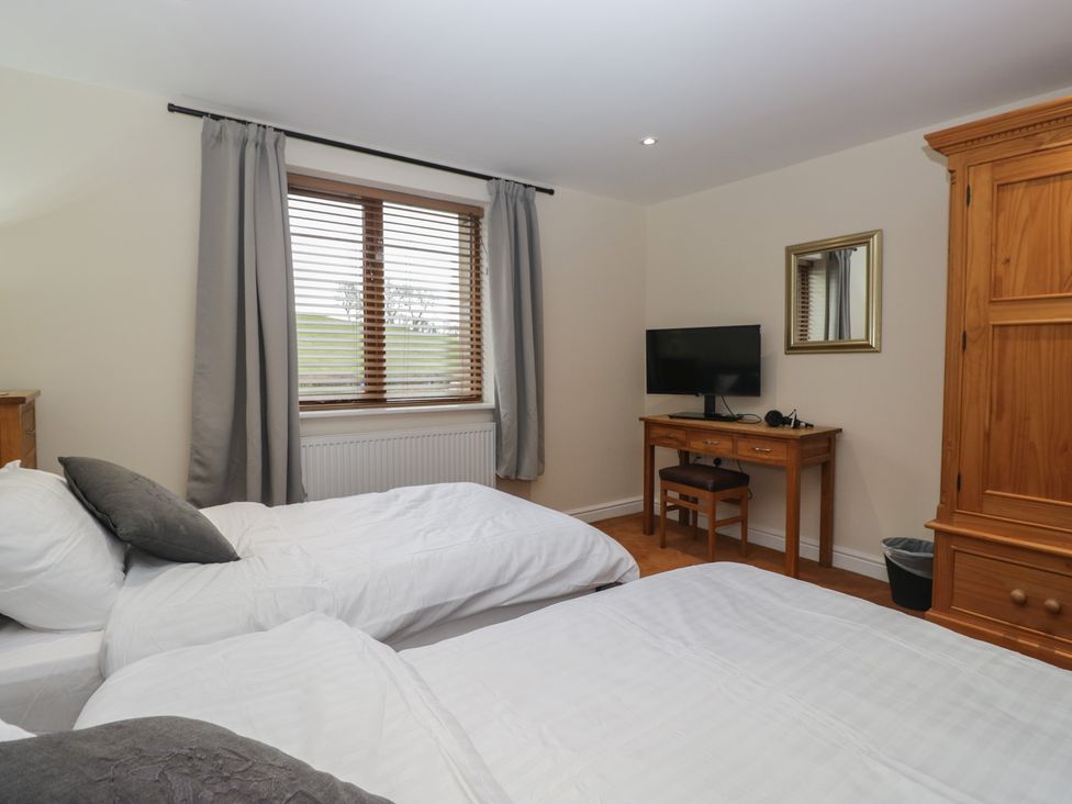 A bedroom with two beds and a desk at 6 Swan House Tewitfield