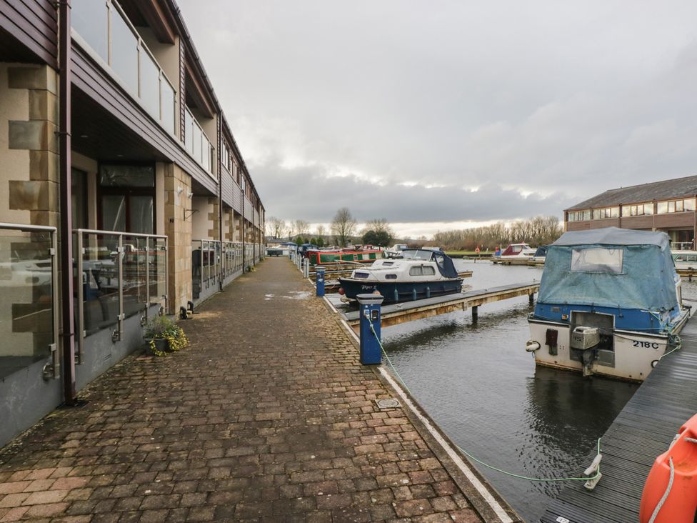 An outdoor dock with boats at 6 Swan House in Tewitfield
