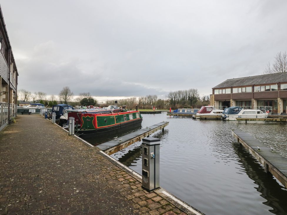 A canal with houseboats and a pathway at 6 Swan House in Tewitfield