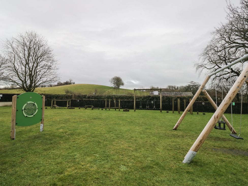 A playground with swings and a climbing frame at 6 Swan House in Tewitfield