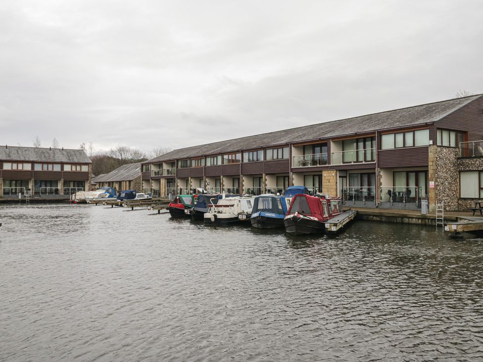 A view of boats at a dock near buildings at 6 Swan House in Tewitfield