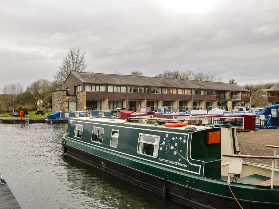 A canal boat beside a building at 6 Swan House in Tewitfield