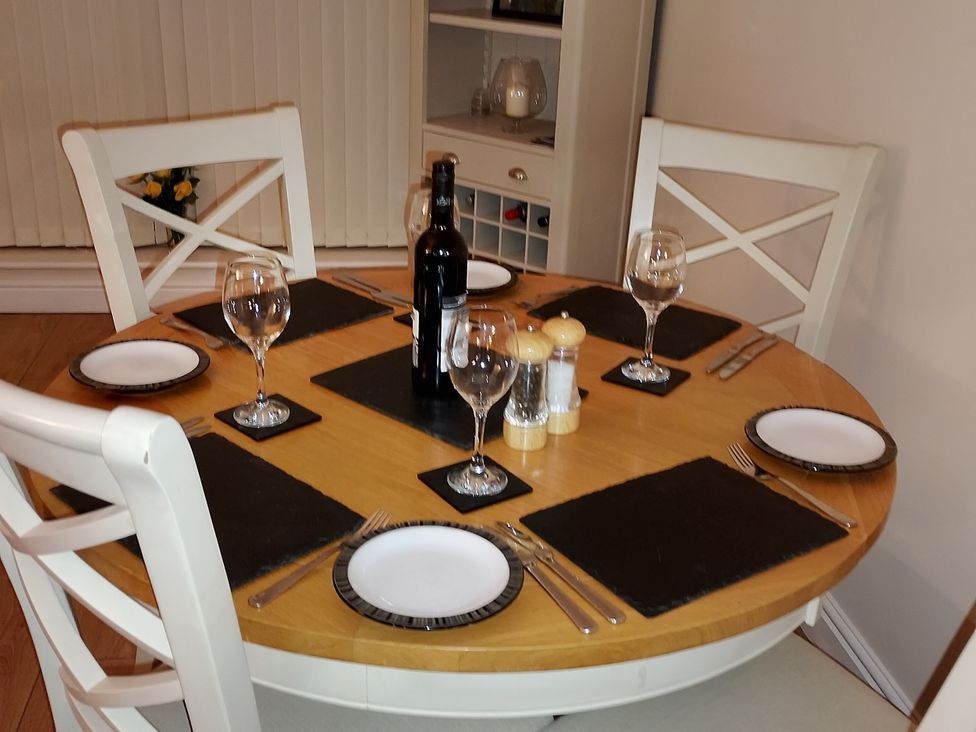 A dining table set with wine and plates at 6 Swan House in Tewitfield