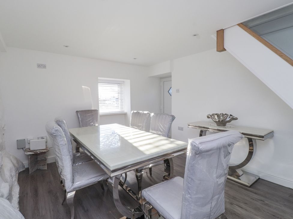 A dining room with a table and chairs at Ty'n Lon Pwllheli