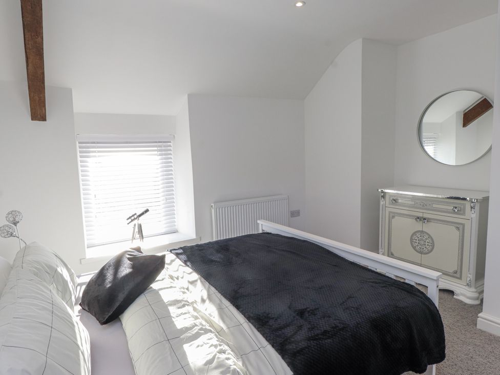 A bedroom with a bed and a cabinet at Ty'n Lon in Pwllheli