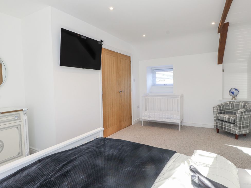 A bedroom with a bed and television at Ty'n Lon Pwllheli