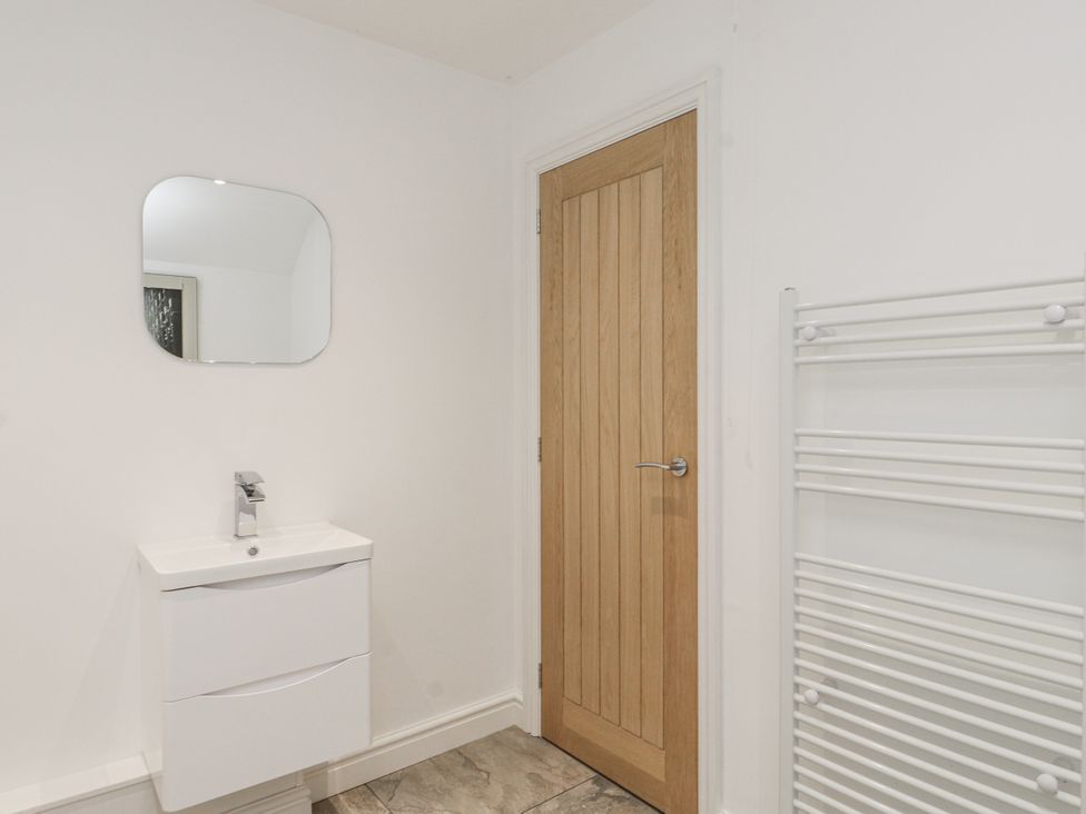 A bathroom with a sink and mirror at Ty'n Lon in Pwllheli