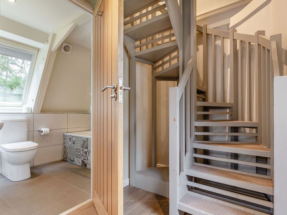 A bathroom with a toilet and staircase at St Ives Studio Spa in Praze-An-Beeble