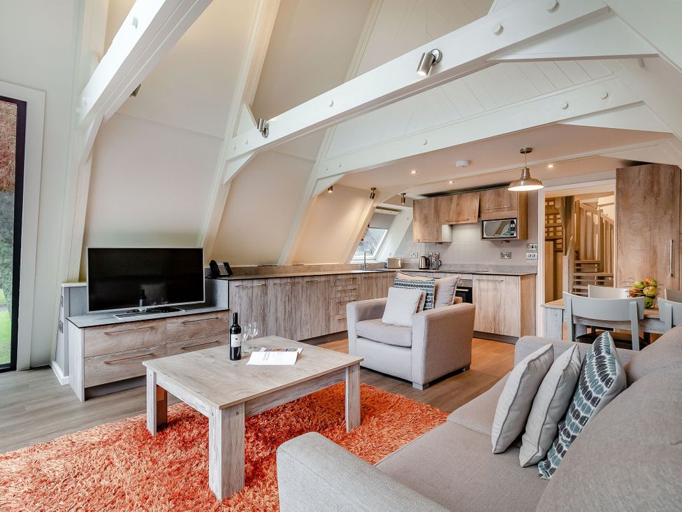 A living room with a television and kitchen units at St Ives Studio Spa, Praze-An-Beeble