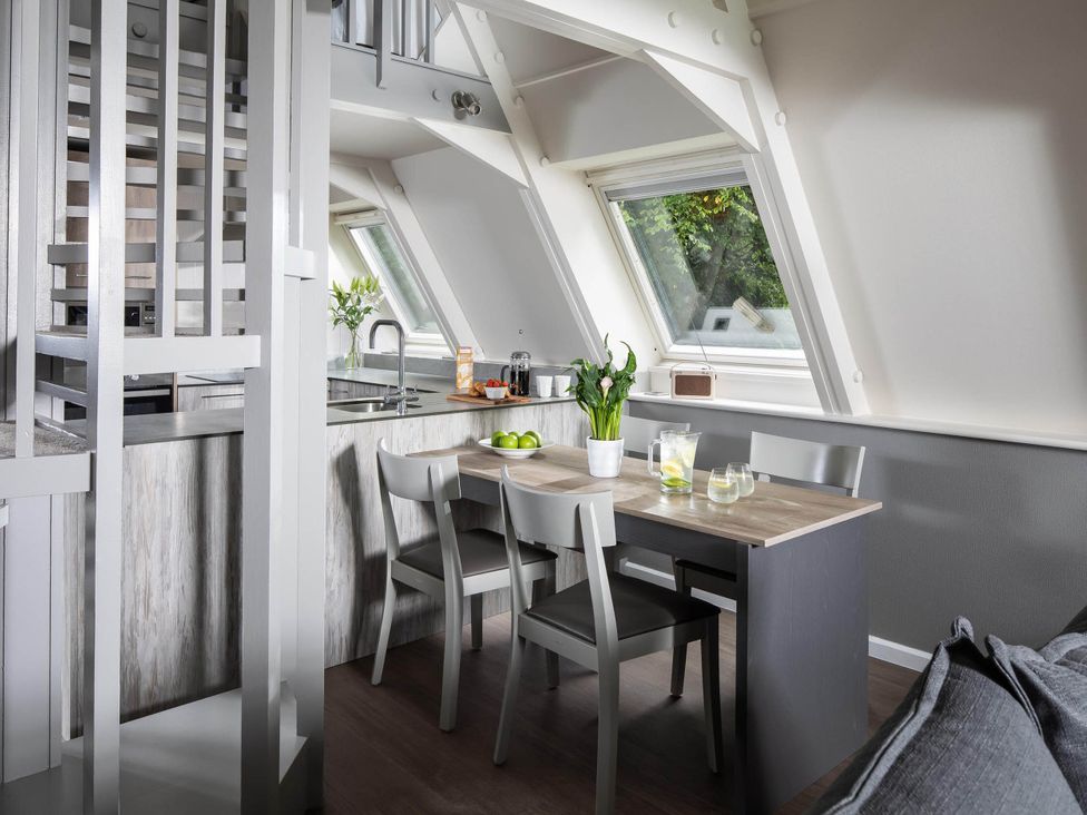 A kitchen with a table and chairs at St Ives Lodge 2 Spa Praze-An-Beeble
