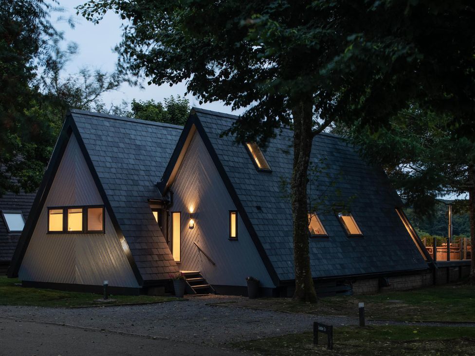 An exterior view of a house with multiple windows and a pathway at St Ives Lodge 3 Spa in Praze-An-Beeble