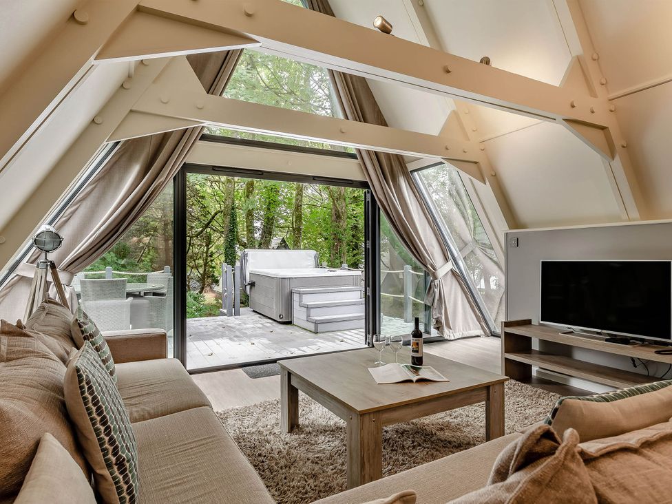 A living room with a sofa and table at St Ives Lodge 3 Spa in Praze-An-Beeble