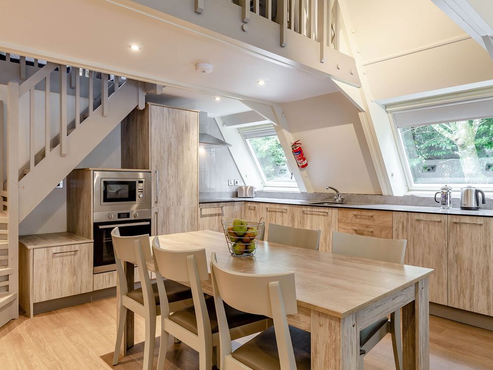A kitchen with a dining table and chairs at St Ives Lodge 3 Spa in Praze-An-Beeble
