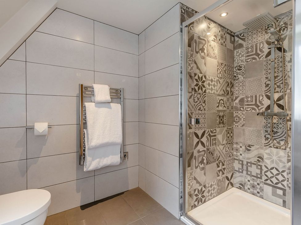 A bathroom with a shower area and towel rail at St Ives Lodge 3 Spa, Praze-An-Beeble