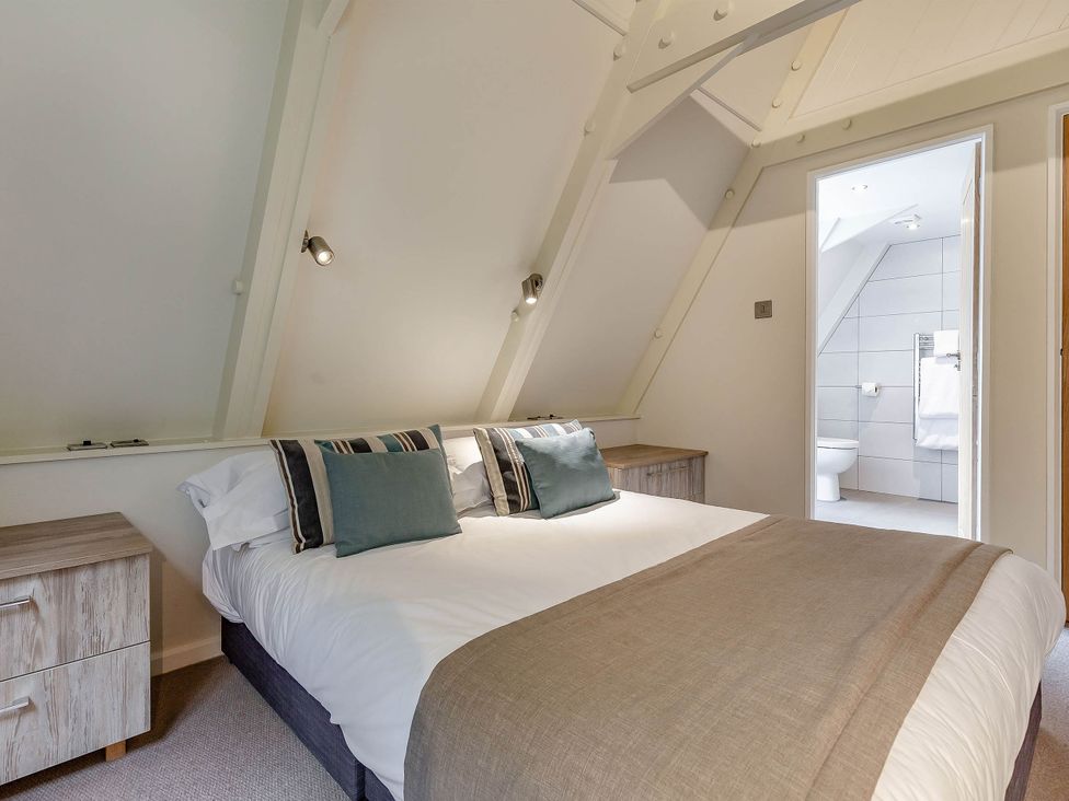 A bedroom with a bed and adjoining bathroom at St Ives Lodge 3 Spa in Praze-An-Beeble