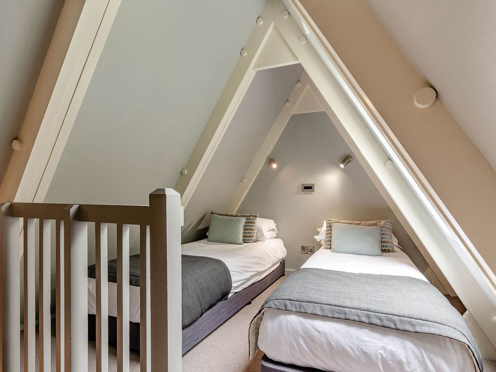 A bedroom with two beds and a decorative pillow at St Ives Lodge 3 Spa Praze-An-Beeble