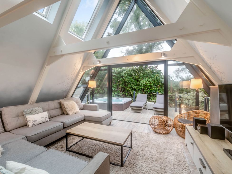 A living room with a sofa and coffee table at Glass Lodge in Praze-An-Beeble