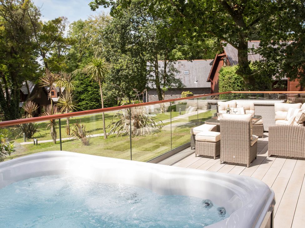 An outdoor space with a hot tub and seating area at Aubyn Lodge Spa Praze-An-Beeble