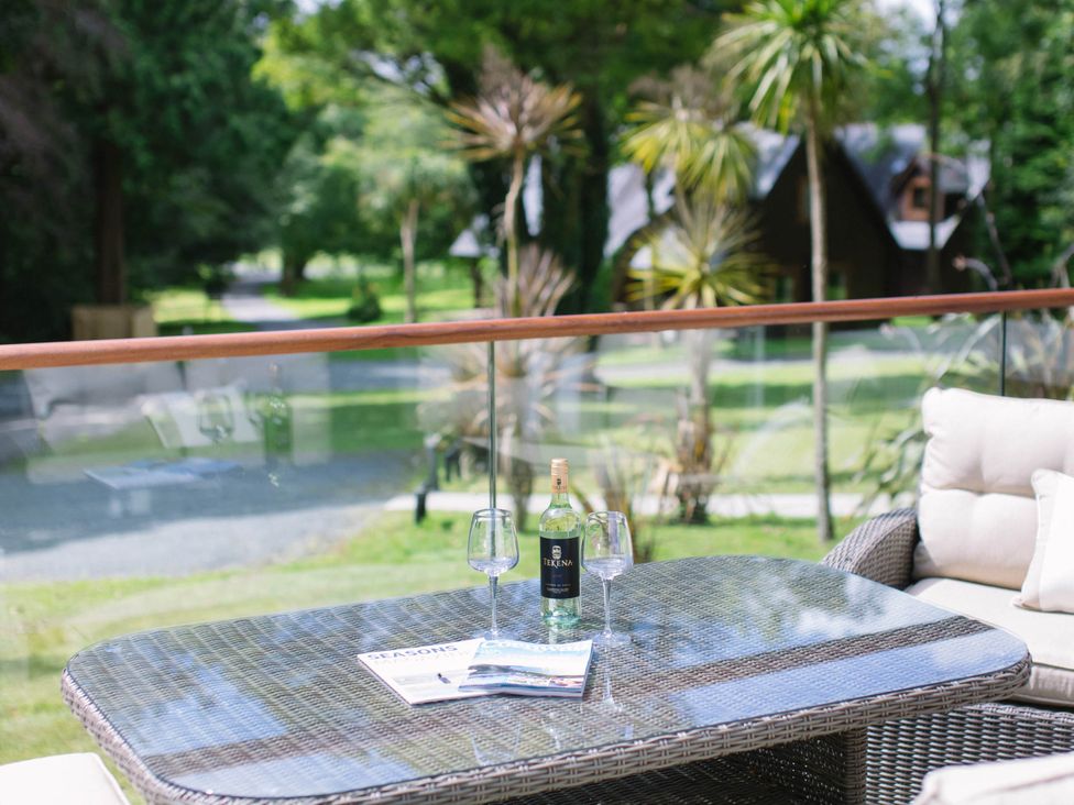 An outdoor seating area with a table and drinks at Aubyn Lodge Spa in Praze-An-Beeble