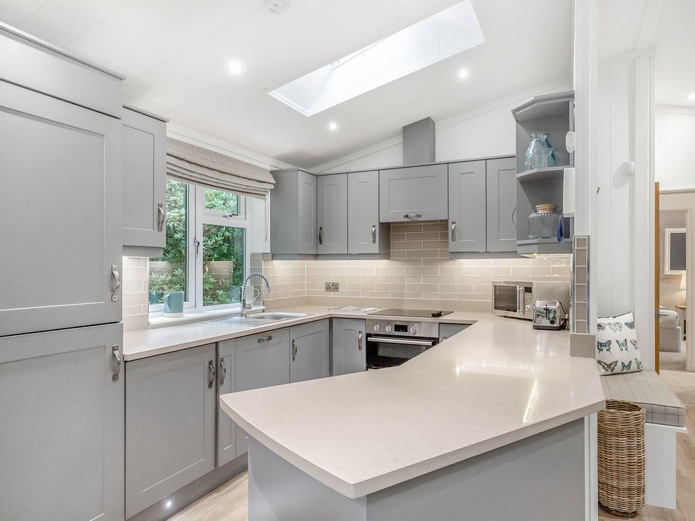 A kitchen with cabinets and a countertop at Aubyn Lodge Spa in Praze-An-Beeble