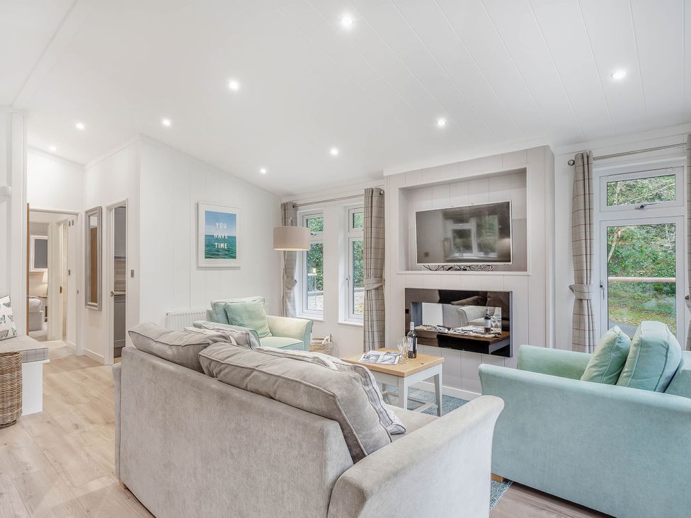 A living room with sofa and television at Aubyn Lodge Spa in Praze-An-Beeble