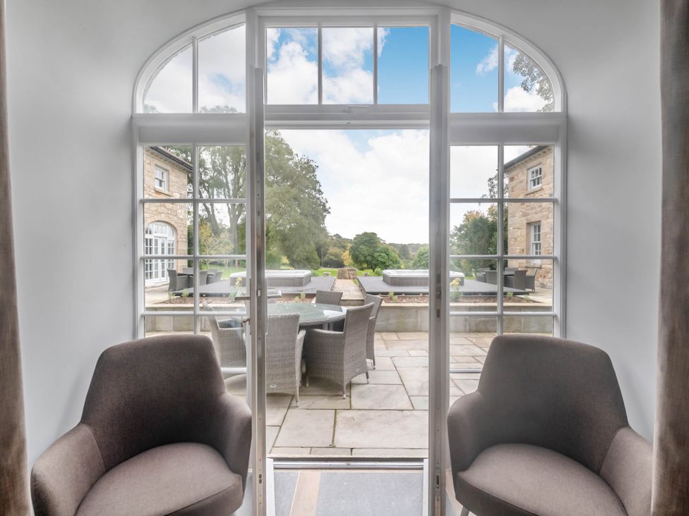 A dining area with chairs and a view of the patio at Coach House Praze-An-Beeble