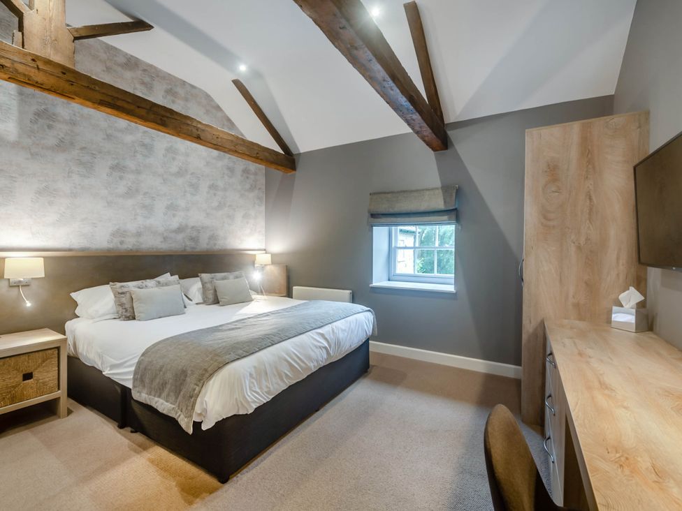 A bedroom with a double bed and desk at Coach House in Praze-An-Beeble