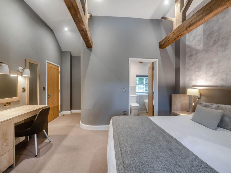 A bedroom with a desk and chair at Coach House Praze-An-Beeble