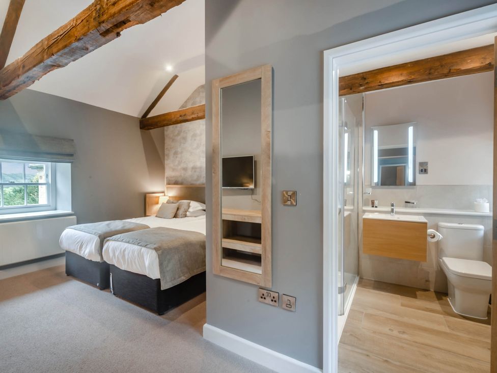A bedroom with a bed and connected bathroom at Coach House Praze-An-Beeble