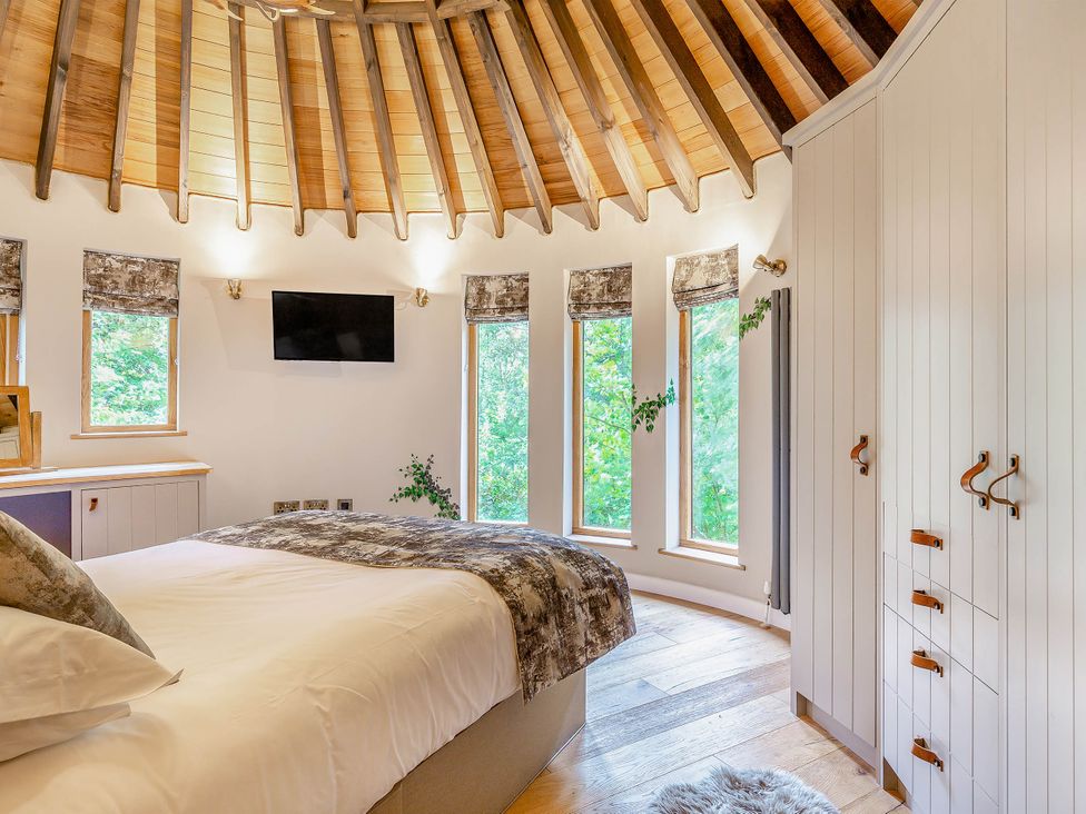 A bedroom with a bed and wardrobe at The Treehouse in Praze-An-Beeble