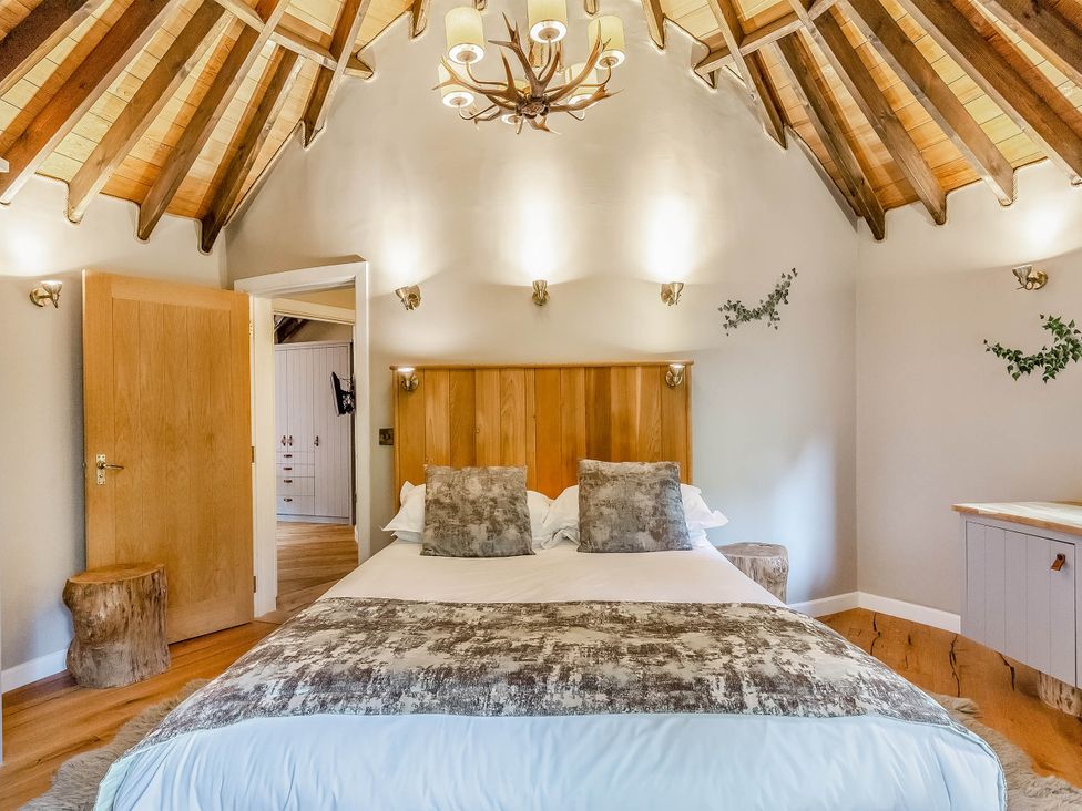 A bedroom featuring a bed, bedside table, and wooden elements at The Treehouse in Praze-An-Beeble