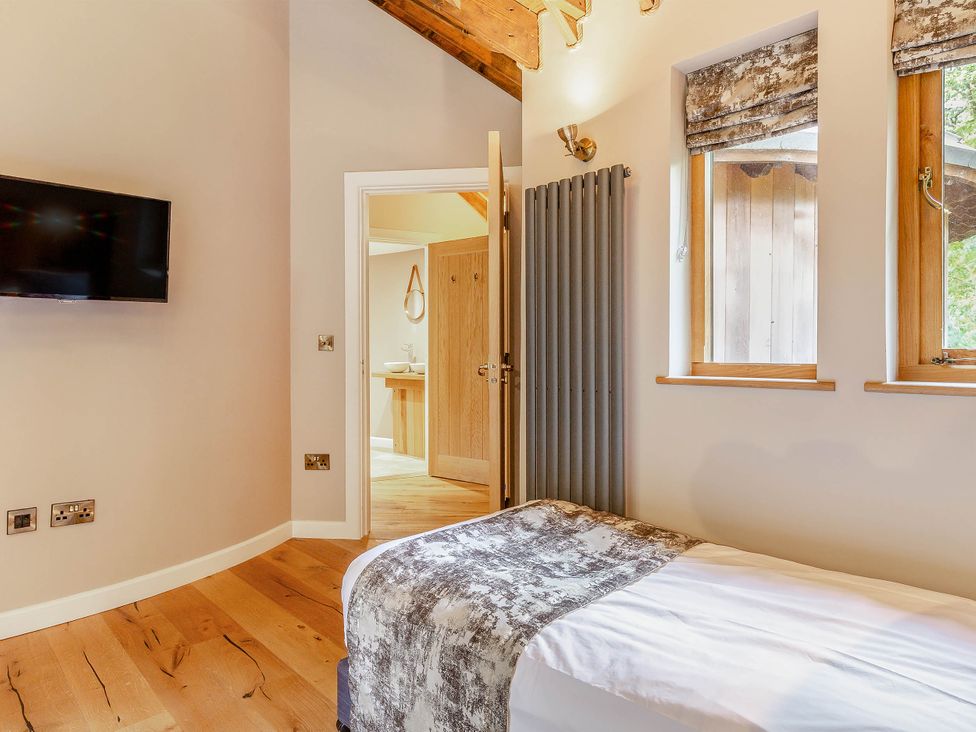 A bedroom with a bed and a television at The Treehouse in Praze-An-Beeble