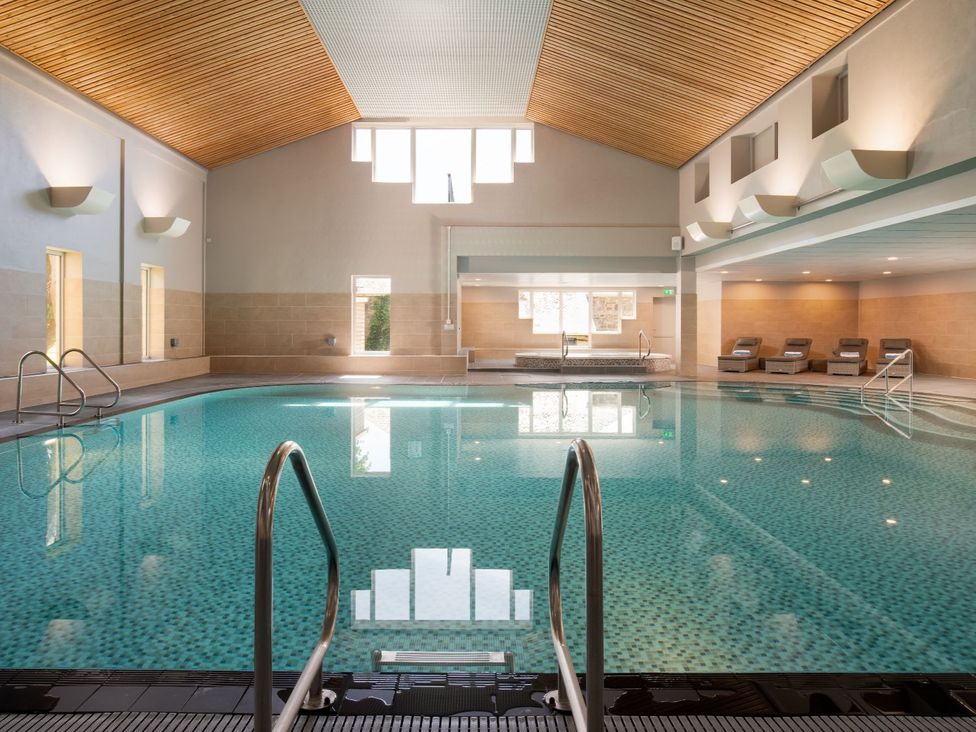 An indoor pool with steps and loungers at The Treehouse in Praze-An-Beeble