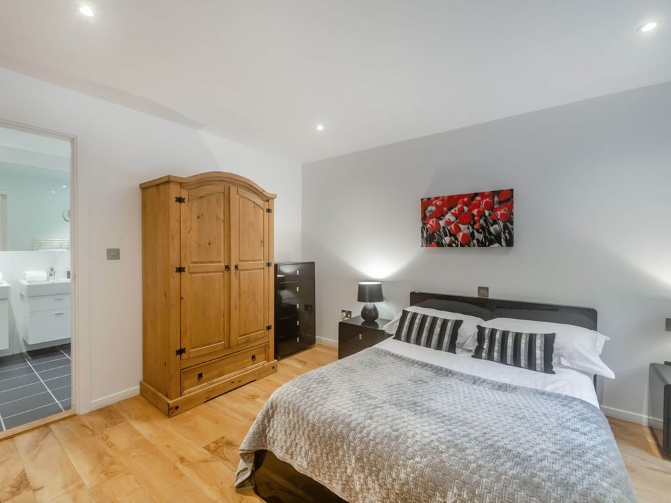 A bedroom with a bed and wardrobe at Cornwall Lodge Spa in Praze-An-Beeble