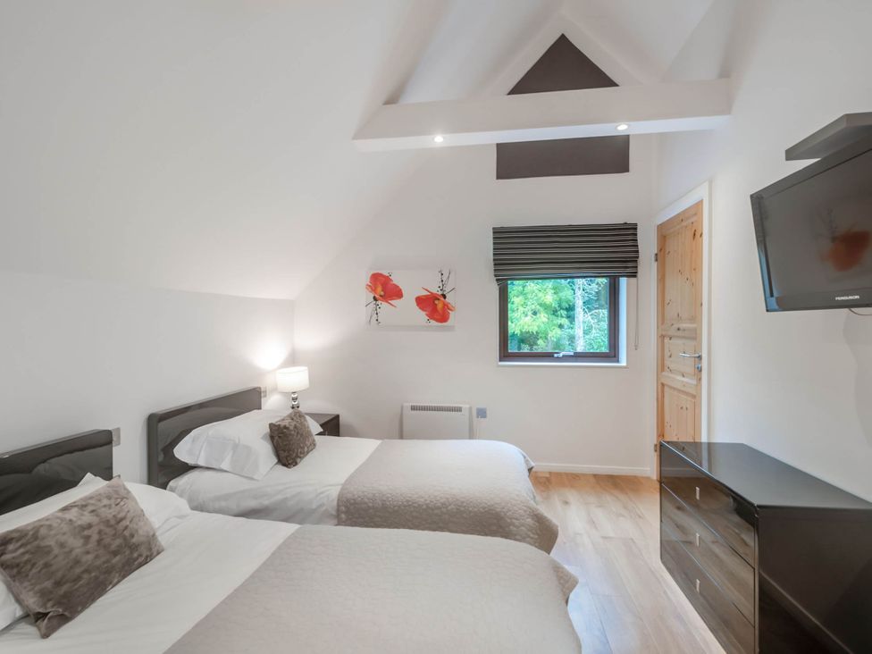 A bedroom with two beds and a window at Cornwall Lodge Spa in Praze-An-Beeble