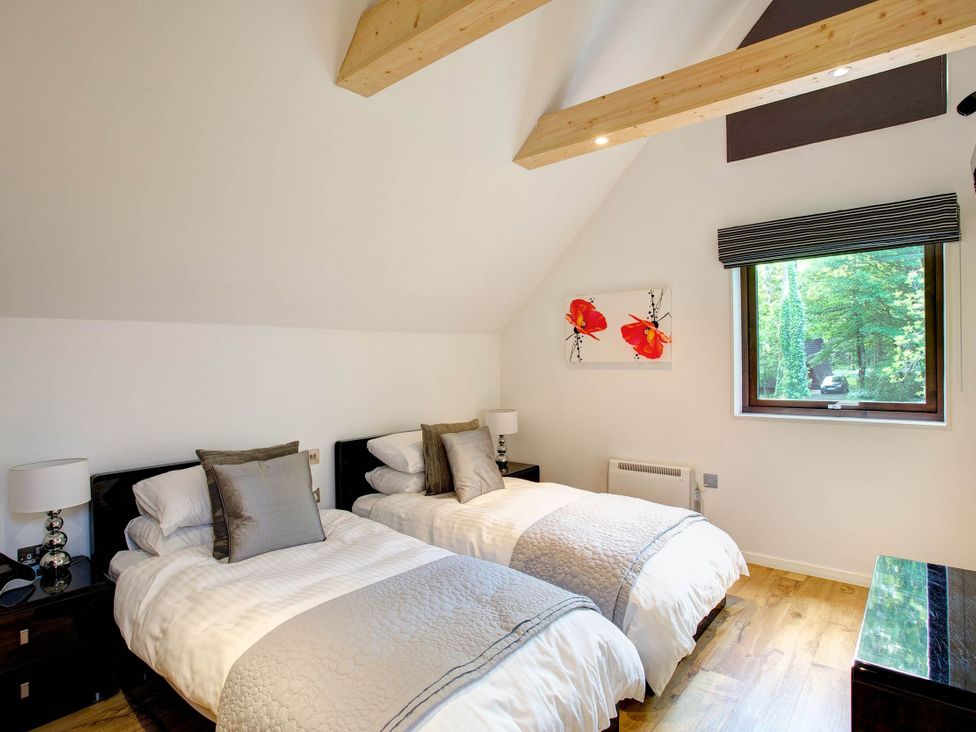 A bedroom with two twin beds and a window at Cornwall Lodge Spa in Praze-An-Beeble