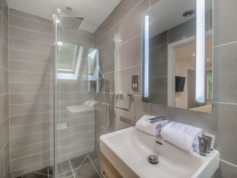 A bathroom with a shower and sink at St Austell Lodge Spa in Praze-An-Beeble