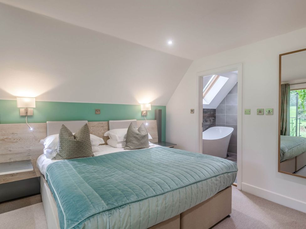 A bedroom with a bed and an adjoining bathroom at St Austell Lodge Spa Praze-An-Beeble